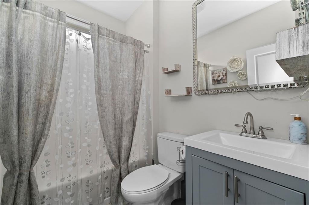 515 Lakeside View Fairburn, GA 30213 - Photo 11 of 43 a bathroom with a sink a toilet a mirror and shower