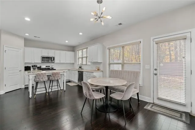 a kitchen with granite countertop white cabinets and stainless steel appliances