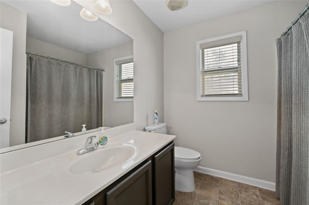 515 Lakeside View Fairburn, GA 30213 - Photo 23 of 43 a bathroom with a sink a toilet and a large mirror