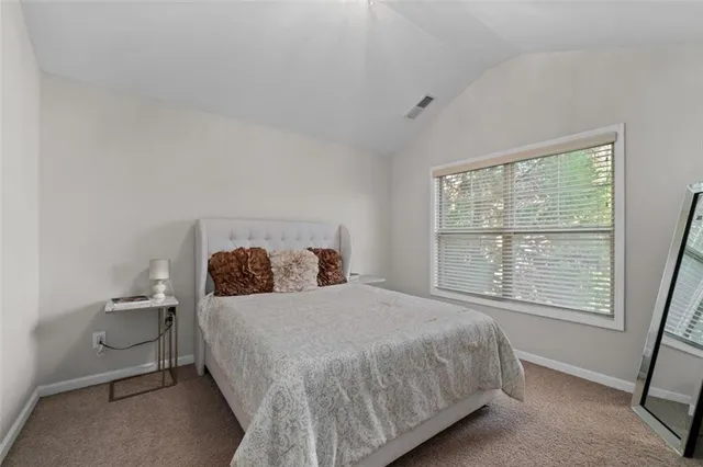 a bedroom with a flat screen tv and a white bed