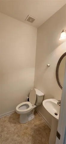 a white toilet sitting next to a bathroom sink