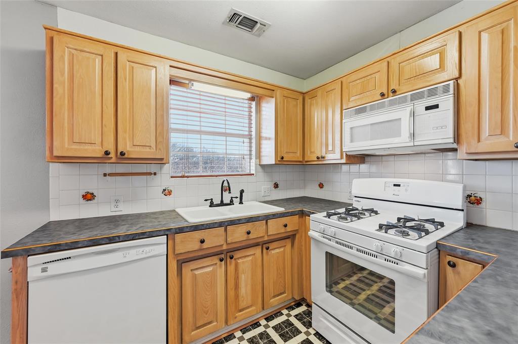 2210 Meadows Lane Sherman, TX 75092 - Photo 33 of 40 a kitchen with stainless steel appliances granite countertop a stove sink and cabinets