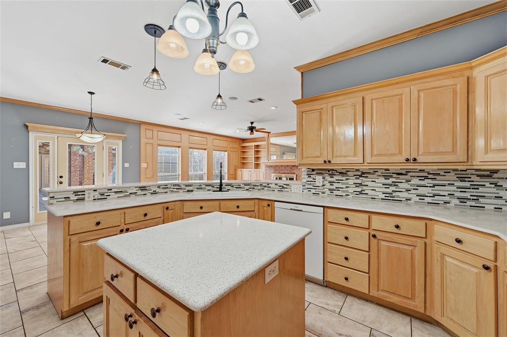 2210 Meadows Lane Sherman, TX 75092 - Photo 9 of 40 a kitchen with stainless steel appliances granite countertop a stove a sink dishwasher and white cabinets with wooden floor