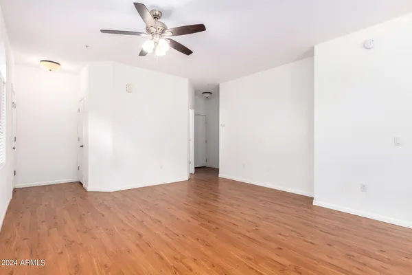 a view of a livingroom with a flat screen tv wooden floor and a ceiling fan