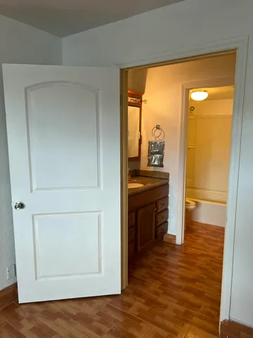 a view of empty room with wooden floor