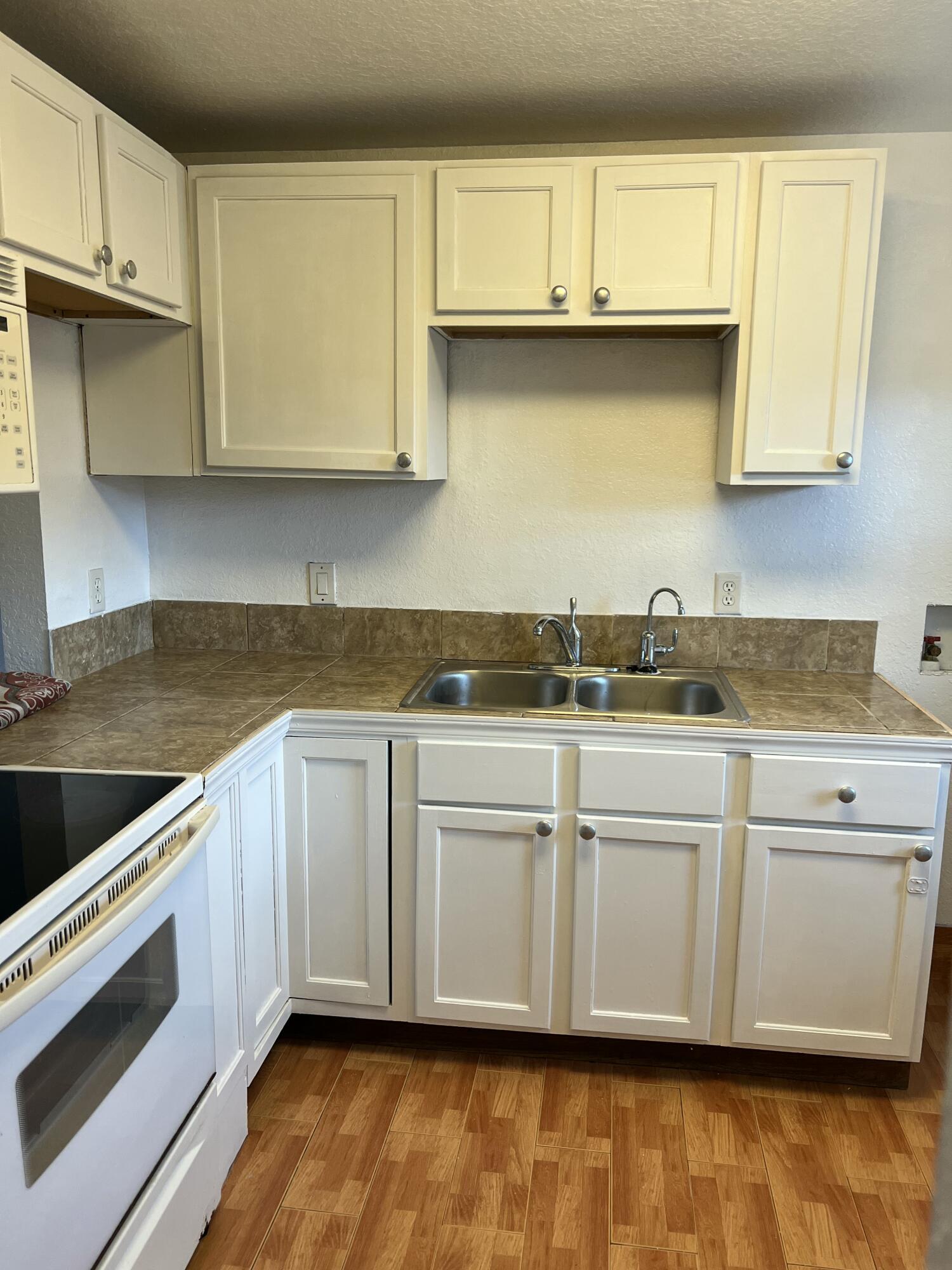 5500 Northwest 2nd Avenue, Unit 121 Boca Raton, FL 33487 - Photo 4 of 28 a kitchen with granite countertop white cabinets and a stove