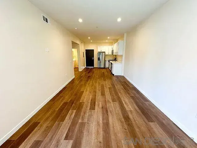 a view of a refrigerator in kitchen and wooden floor
