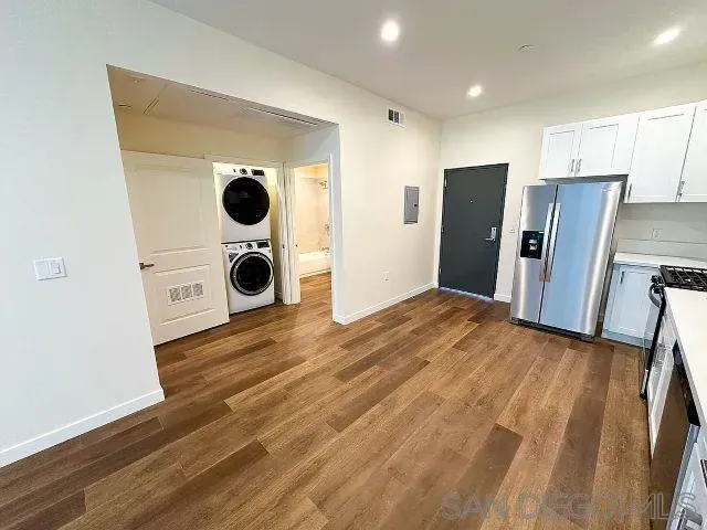 a view of a room with wooden floor and a window