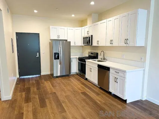 a kitchen with stainless steel appliances granite countertop a stove a sink and a refrigerator