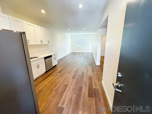 a kitchen with wooden floors and appliances