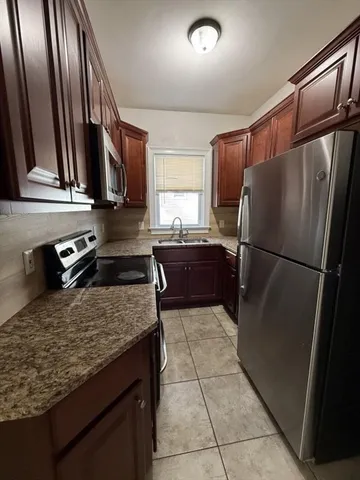 a kitchen with granite countertop a refrigerator and a sink