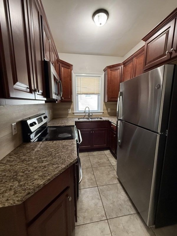 517 President Fall River, Unit 1 Fall River, MA 02720 - Photo 2 of 13 a kitchen with granite countertop a refrigerator and a sink