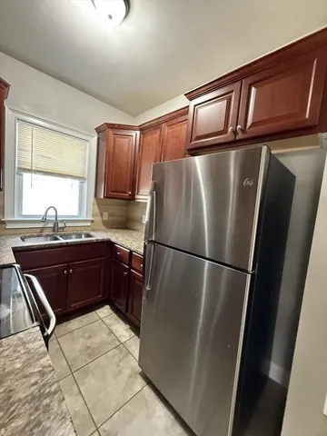 a kitchen with stainless steel appliances granite countertop a refrigerator and a sink