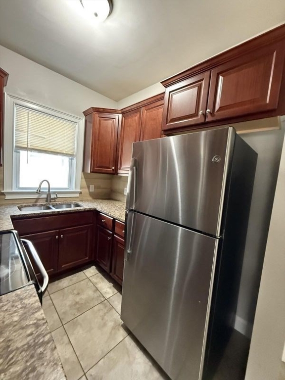 517 President Fall River, Unit 1 Fall River, MA 02720 - Photo 3 of 13 a kitchen with stainless steel appliances granite countertop a refrigerator and a sink