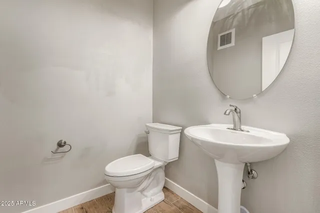 a bathroom with a sink a toilet and mirror