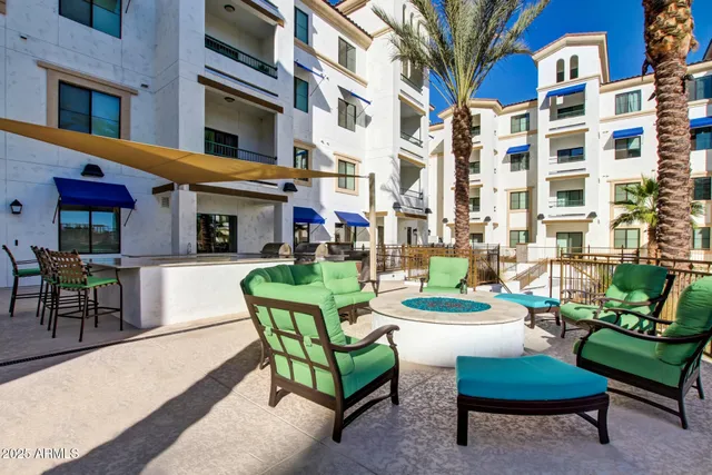 a view of a patio with dining table and chairs under an umbrella