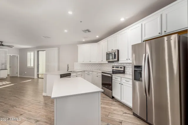 a kitchen with a refrigerator a stove top oven a sink and cabinets