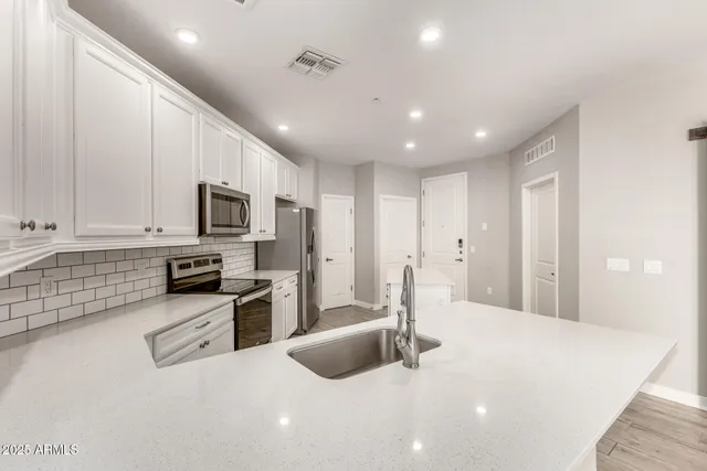 a kitchen with stainless steel appliances granite countertop a stove a sink and a refrigerator