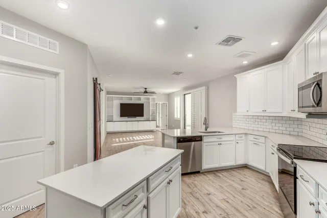 a kitchen with granite countertop a sink stove top oven and cabinets