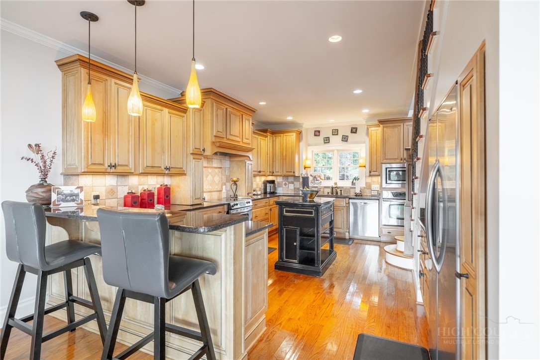 50 Mitchell River Ridge Thurmond, NC 28683 - Photo 15 of 43 a kitchen with stainless steel appliances kitchen island granite countertop a table chairs and a refrigerator