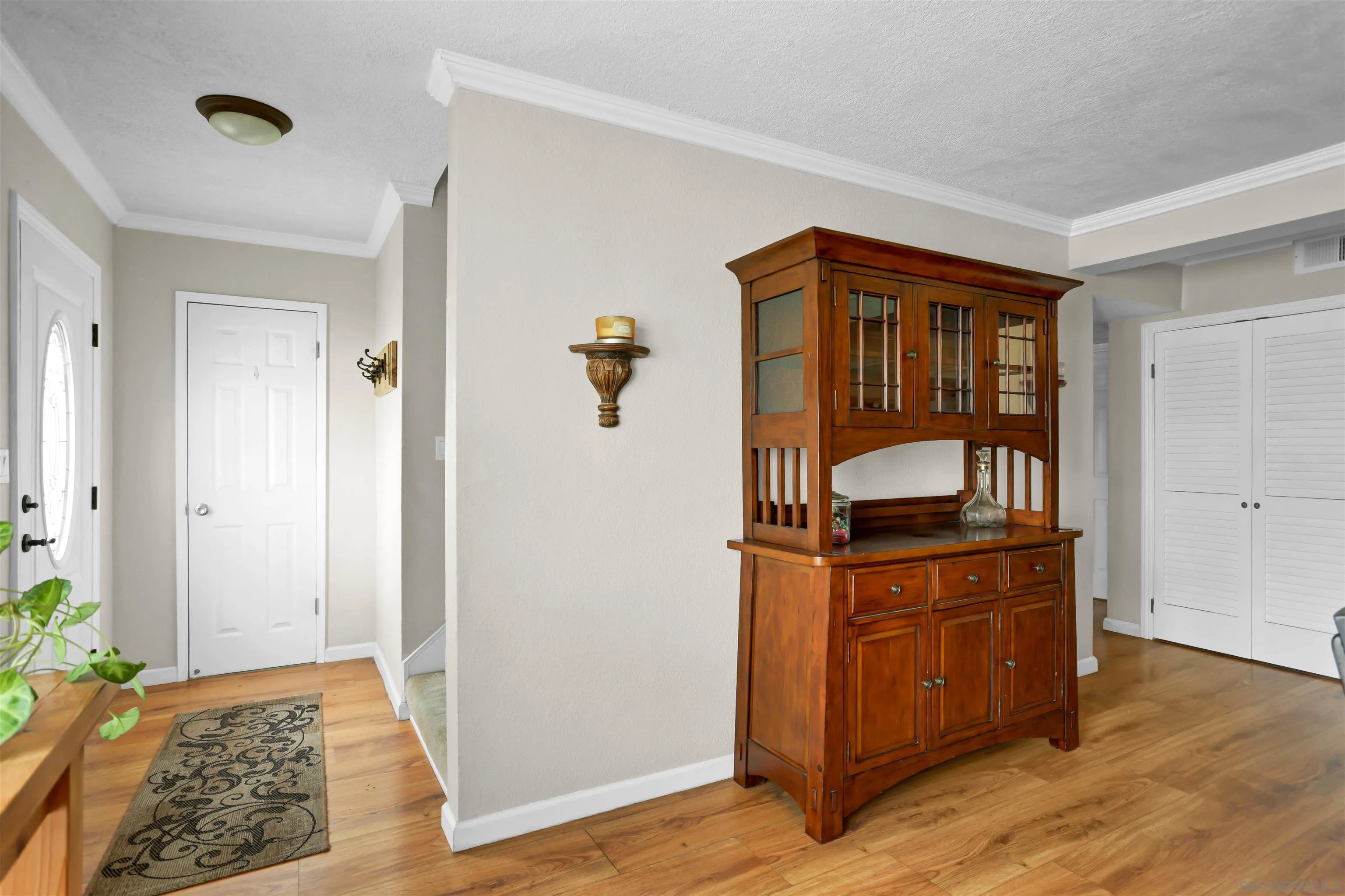 8009 Shantung Drive Santee, CA 92071 - Photo 7 of 39 a view of a livingroom with wooden floor and a cabinet door