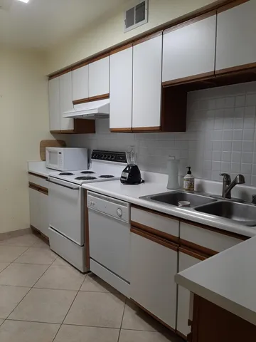 a kitchen with stainless steel appliances granite countertop a sink a stove and cabinets