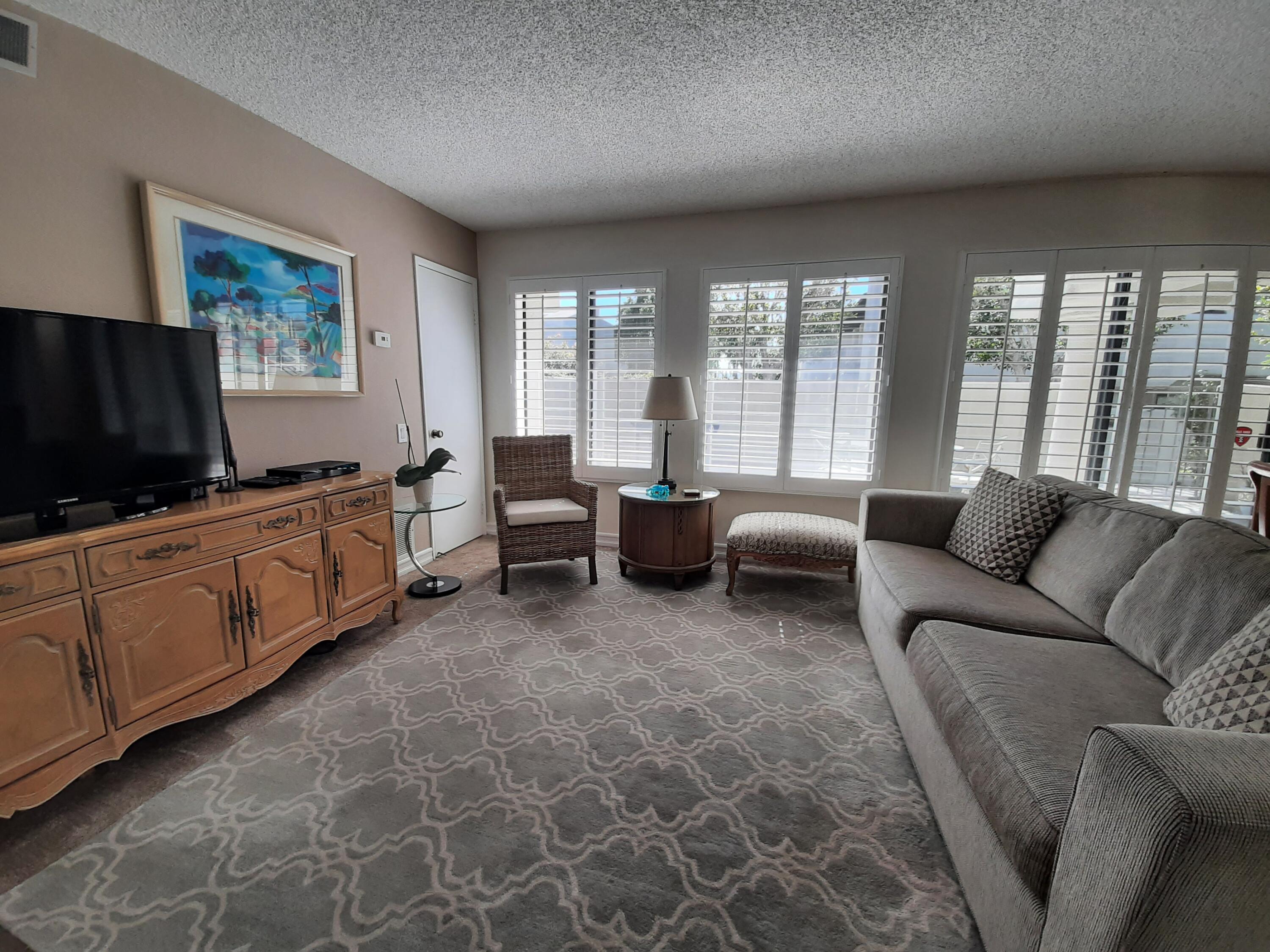 1100 East Amado Road, Unit 14D1 Palm Springs, CA 92262 - Photo 2 of 18 a living room with furniture and a flat screen tv