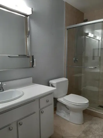 a bathroom with a sink a toilet and shower