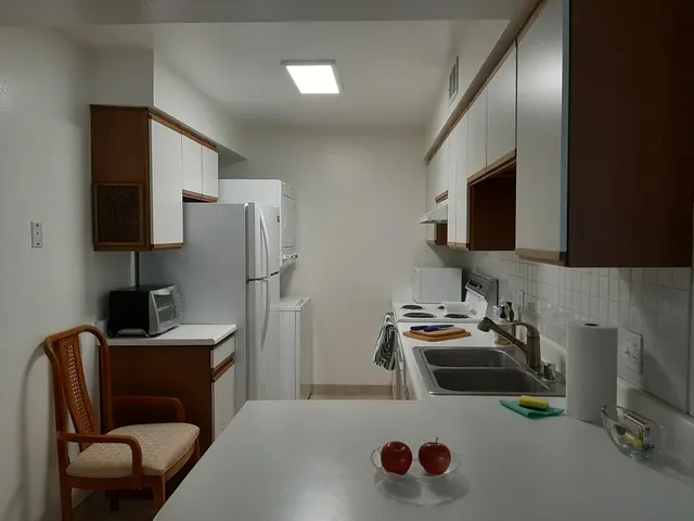 a kitchen with stainless steel appliances granite countertop a sink dishwasher stove and refrigerator with wooden floor