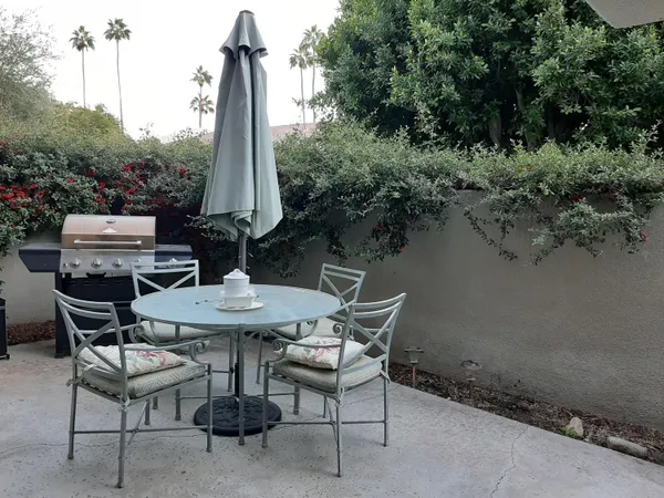 a view of a patio with table and chairs and potted plants