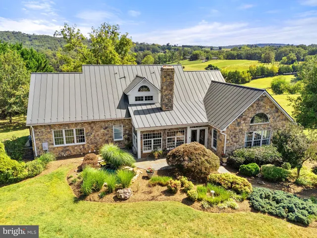 a view of a house with a yard and potted plants