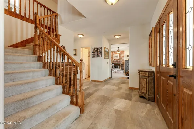 a view of a dining room and livingroom with furniture a floor to ceiling window and a flat screen tv
