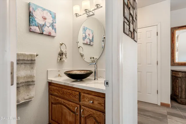 a bathroom with a granite countertop sink a mirror and bathtub