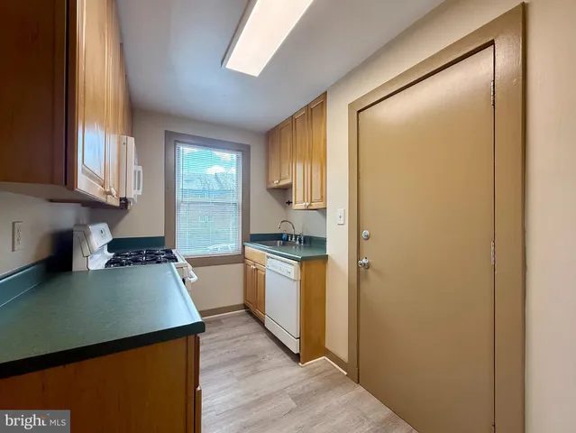 a kitchen with a refrigerator and a stove top oven