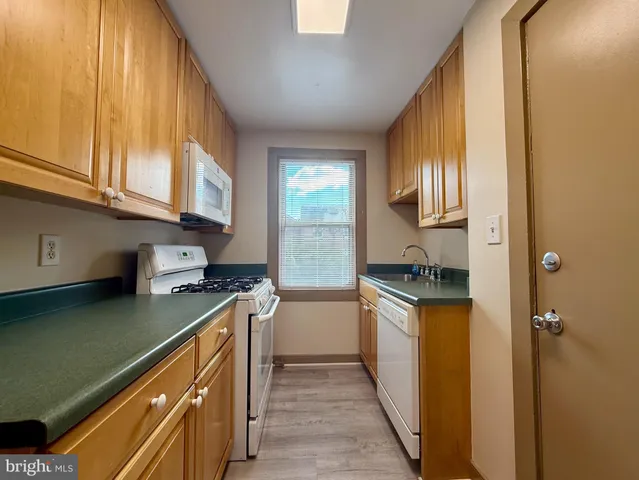 a kitchen with a sink stove top oven and cabinets