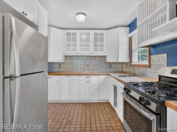 56375 Bates Road New Baltimore, MI 48051 - Photo 19 of 35 White cabinetry, wood-finish countertops, stainless steel appliances, textured backsplash, and tiled flooring