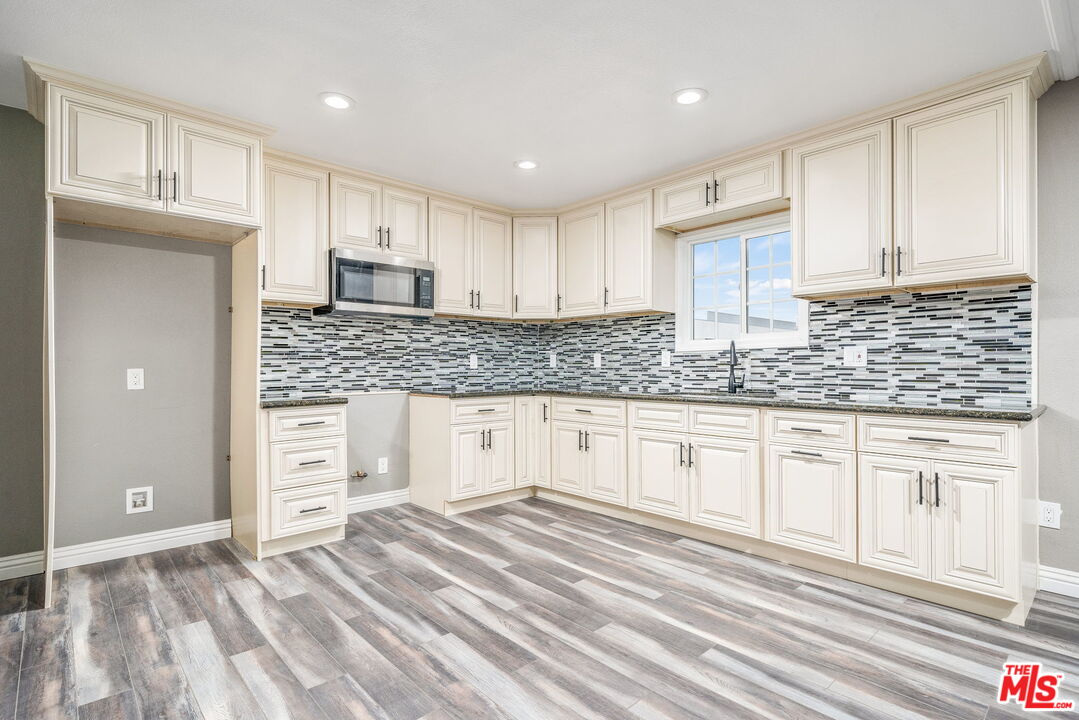 6860 Murray Street Riverside, CA 92504 - Photo 11 of 38 a kitchen with granite countertop a sink and cabinets