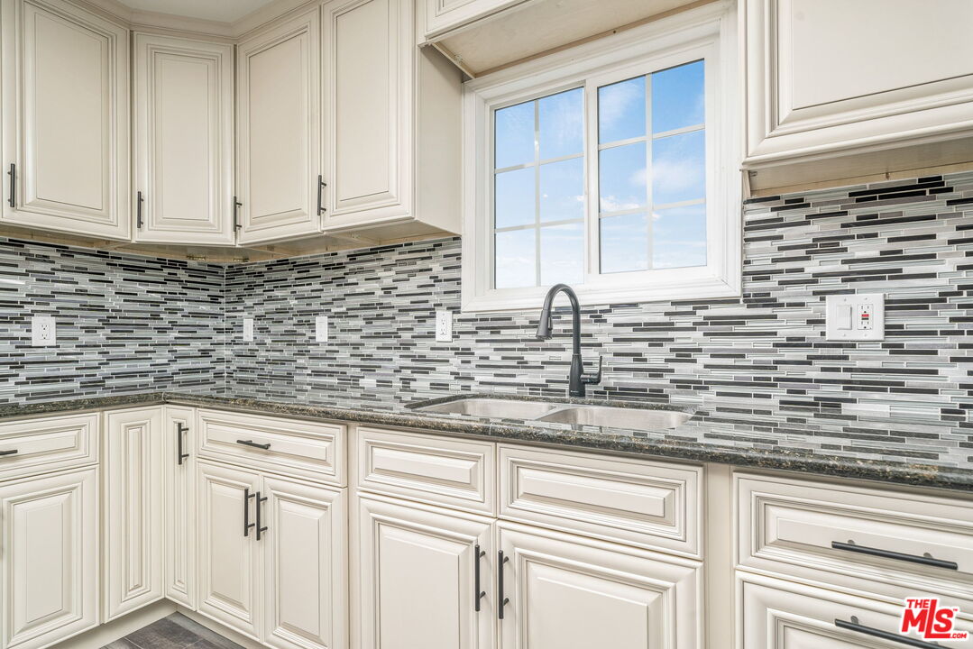 6860 Murray Street Riverside, CA 92504 - Photo 12 of 38 a kitchen with stainless steel appliances white cabinets and a window