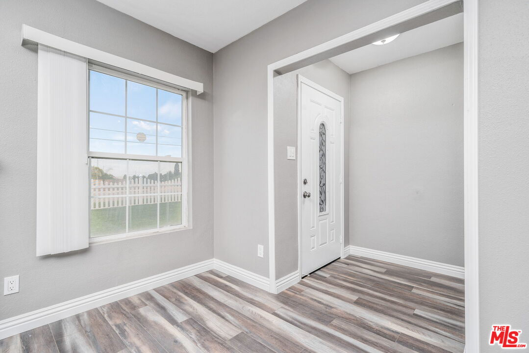 6860 Murray Street Riverside, CA 92504 - Photo 7 of 38 a view of an empty room with wooden floor and a window