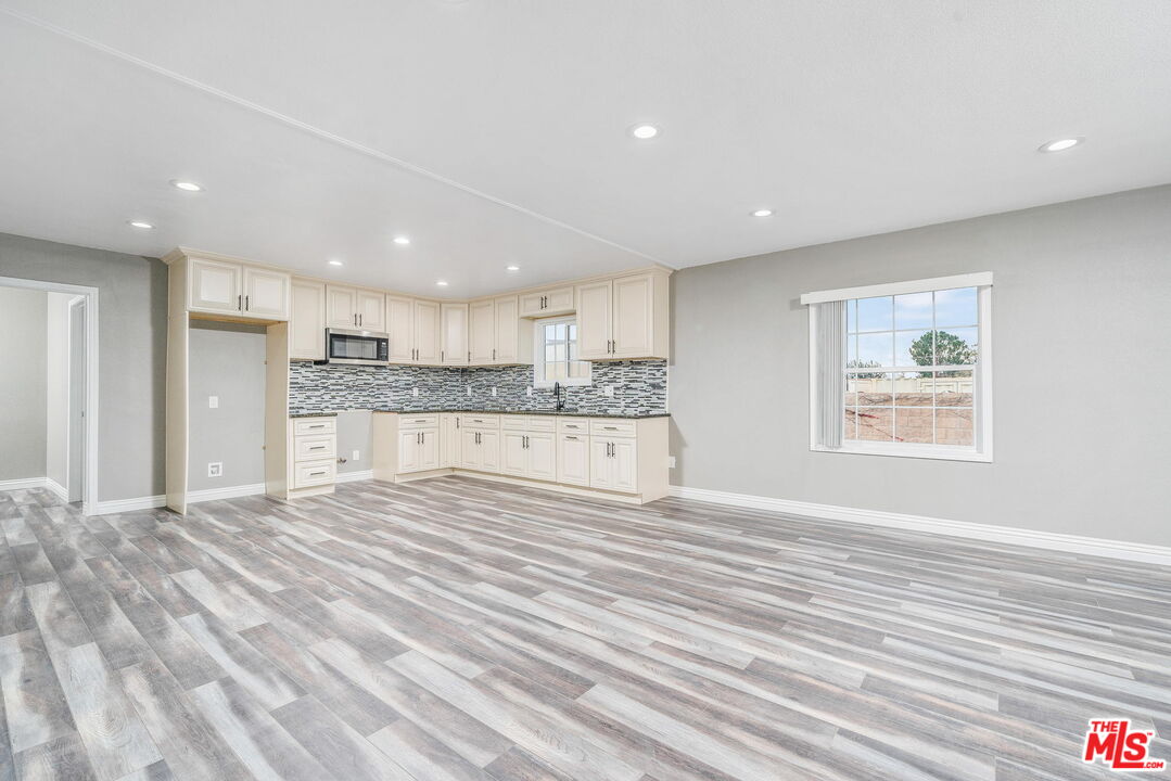 6860 Murray Street Riverside, CA 92504 - Photo 10 of 38 a large kitchen with stainless steel appliances kitchen island a large counter top and a stove top oven