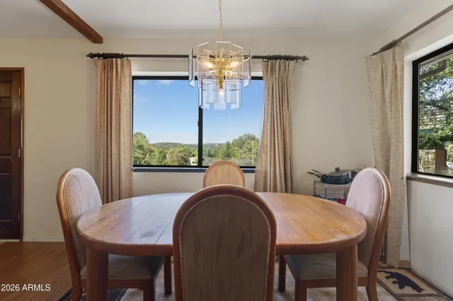 a view of a dining room with furniture a chandelier and wooden floor
