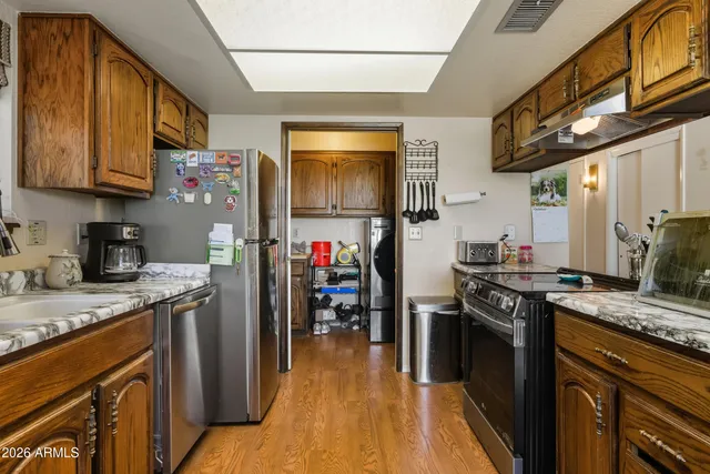 a kitchen with stainless steel appliances granite countertop a stove refrigerator sink and cabinets