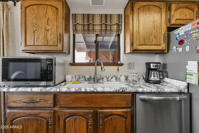 a utility room with stainless steel appliances granite countertop a sink a stove and washer