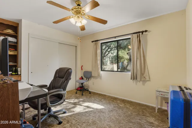 a view of a workspace with furniture and a window