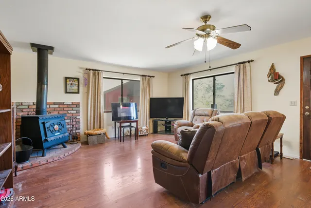 a living room with furniture a ceiling fan and a flat screen tv