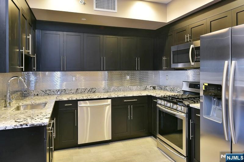 8-10 Whitehall Road, Unit 3 Towaco, NJ 07082 - Photo 3 of 12 a kitchen with stainless steel appliances granite countertop a stove sink and cabinets