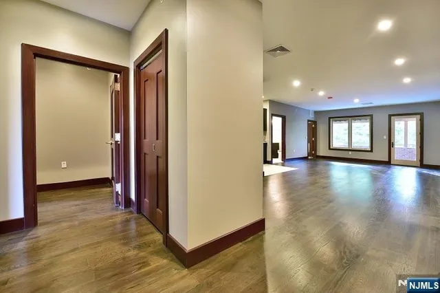 a view of a big room with wooden floor and windows
