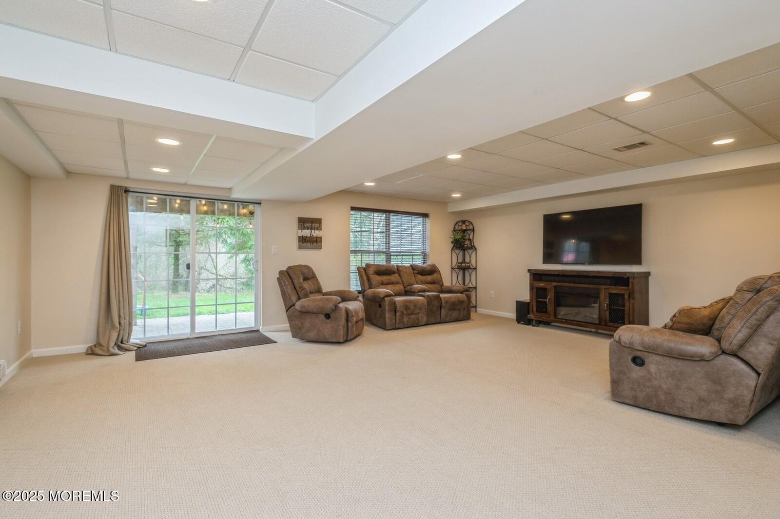 33 Brookfield Drive Jackson, NJ 08527 - Photo 18 of 23 a living room with furniture a flat screen tv and a large window