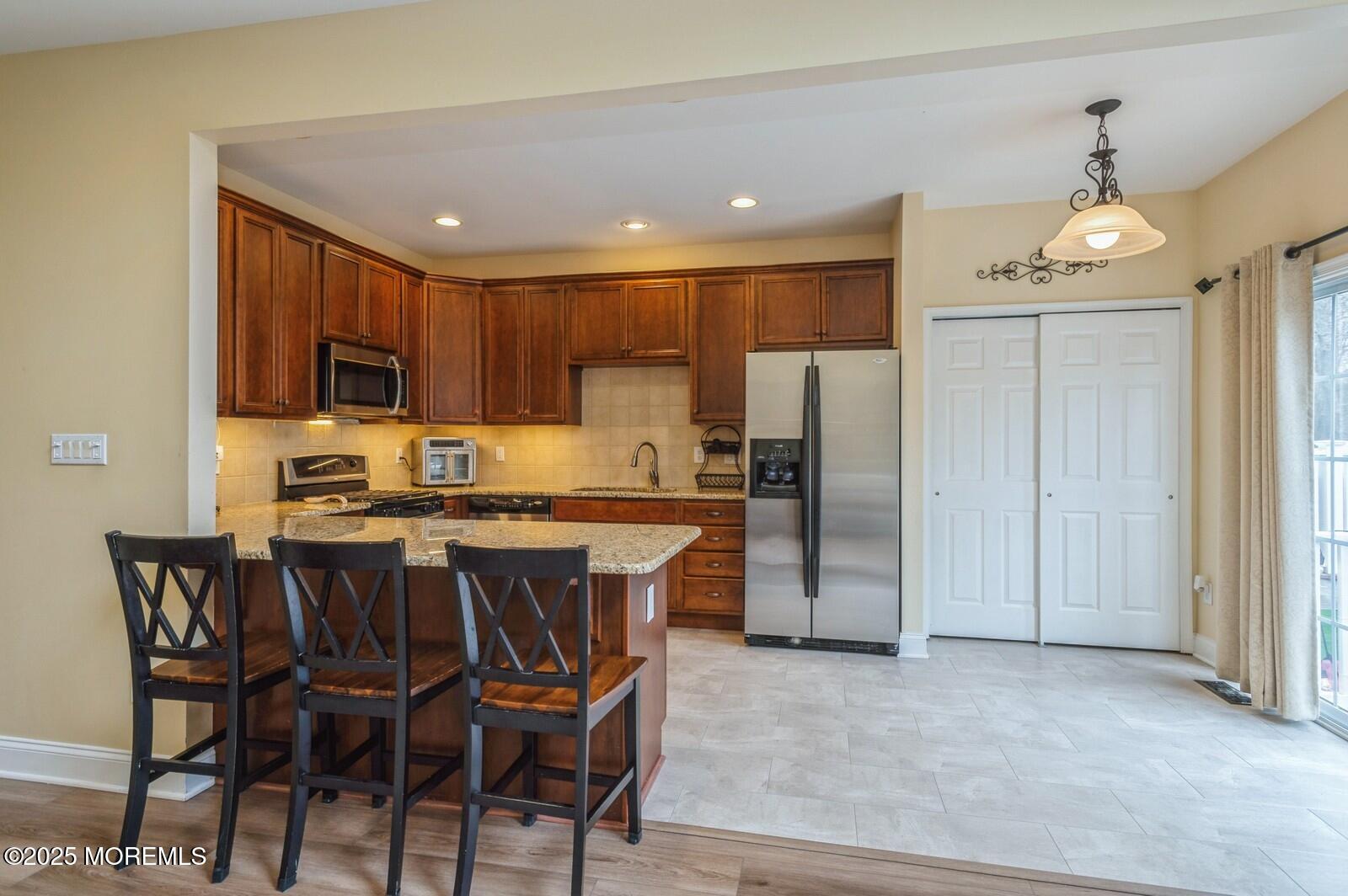 33 Brookfield Drive Jackson, NJ 08527 - Photo 4 of 23 a kitchen with stainless steel appliances granite countertop a stove a refrigerator a sink a dining table and chairs