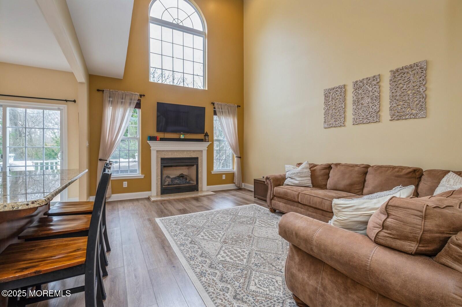 33 Brookfield Drive Jackson, NJ 08527 - Photo 9 of 23 a living room with furniture a flat screen tv and a fireplace